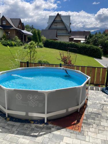 a large hot tub sitting on a patio with a yard at Chatka u Staszka in Małe Ciche