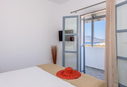 ein roter Hut, der auf einem Bett in einem Zimmer sitzt in der Unterkunft eLea in Adamas