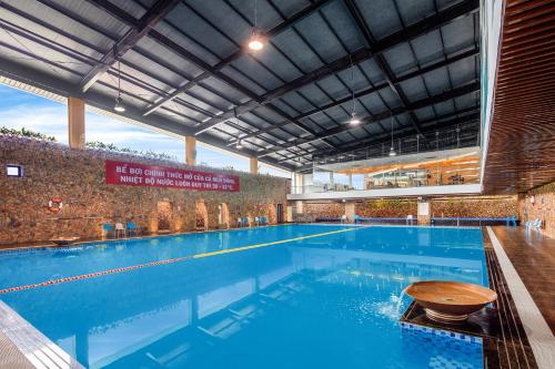 a large swimming pool with blue water in a building at Ravatel Luxury Hotel Bac Giang in Bắc Giang
