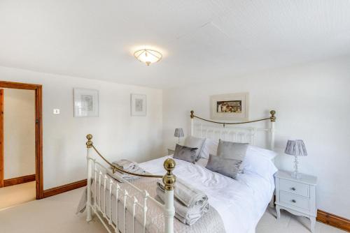 a bedroom with a white bed and a lamp at Darwen in Rugeley