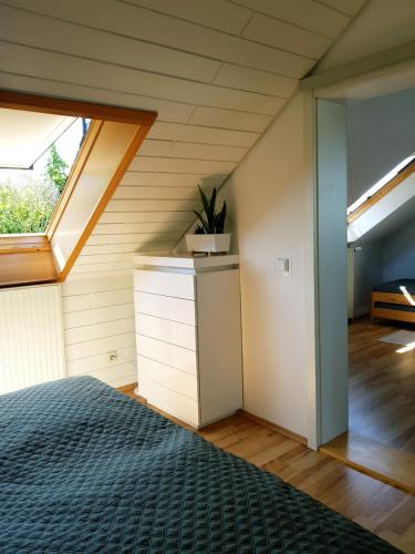 an attic bedroom with a bed and a window at Casa Blanca in Niestetal