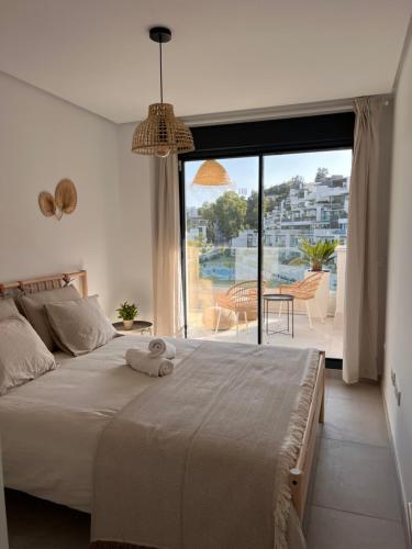 um quarto com uma cama grande e uma janela grande em Tropical penthouse with big roof terrace em Málaga