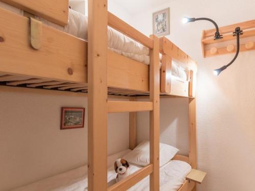 ein Schlafzimmer mit Etagenbetten mit einem Hund auf dem unteren Etagenbett in der Unterkunft Appartement Saint-Chaffrey , 1 pièce, 4 personnes - FR-1-330E-44 in Saint-Chaffrey