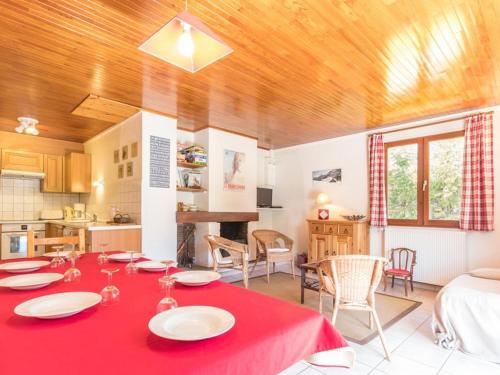 une cuisine et un salon avec une table et un tissu de table rouge dans l'établissement Appartement chaleureux 8 pers, proche pistes, cheminée - FR-1-330E-25, à Saint-Chaffrey