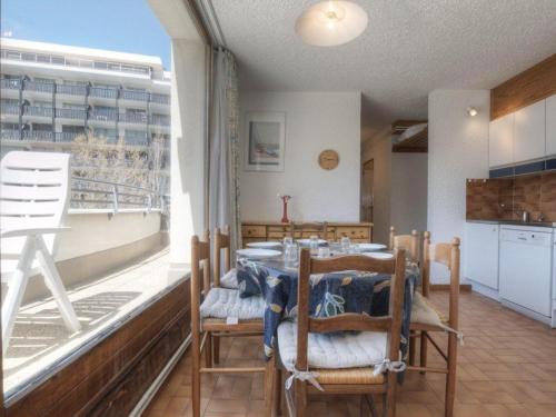 une salle à manger avec une table et une grande fenêtre dans l'établissement Appartement cabine 6 pers avec balcons, proche pistes - Serre-Chevalier, Chantemerle - FR-1-330E-28, à Saint-Chaffrey