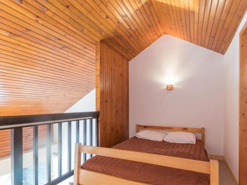un lit dans une chambre avec un plafond en bois dans l'établissement Appartement 6 pers. à Chantemerle, Serre-Chevalier - Balcon, Parking, 2 étoiles - FR-1-330E-34, à Saint-Chaffrey