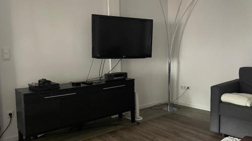 a living room with a tv on top of a dresser at OASE im grünen Hinterhof, EG, Ruhe, Terrasse, Carport, free PayTV, Kaffee&Tee, Fahrräder in Duisburg