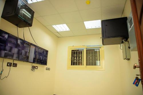 a room with a window and a tv on the wall at فندق نفرتيتى جمصه in ‘Izbat Jamaşah al Gharbīyah