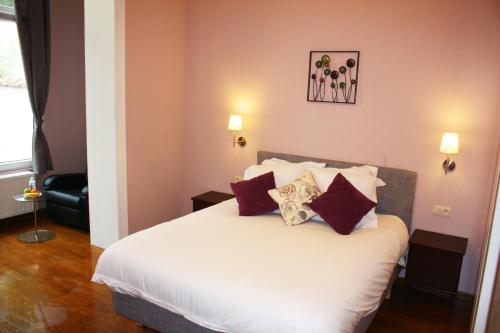 a bedroom with a large white bed with red pillows at EU B&B in Brussels