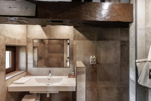 een badkamer met een wastafel en een spiegel bij Casa Rural Arotzenea in Hondarribia