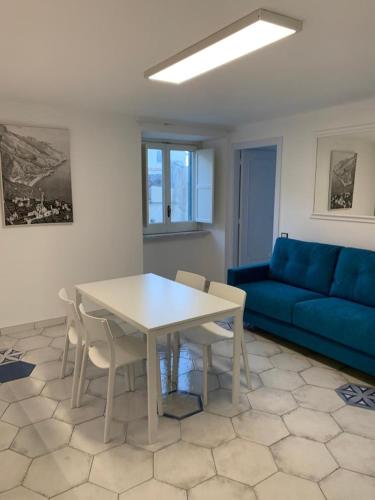 a living room with a table and a blue couch at Le Case di Don Andrea in Minori