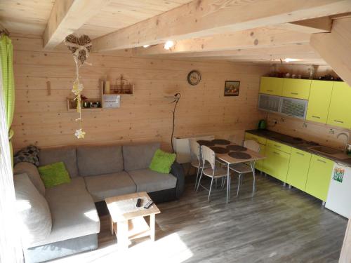 Domki pod Pilskiem في كوربييلوف: غرفة معيشة مع أريكة ومطبخ