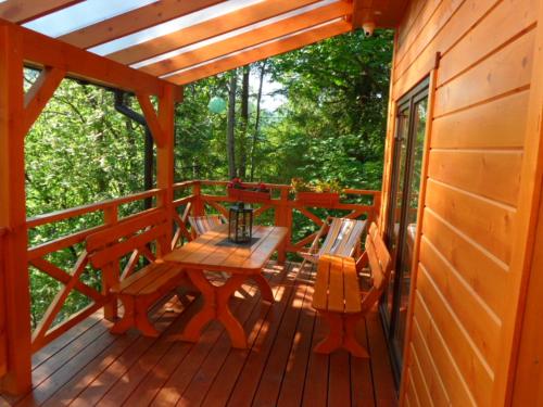a wooden deck with a table and bench on a cabin at Domki pod Pilskiem in Korbielów