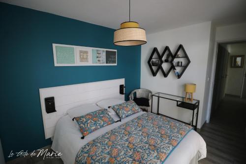 ein Schlafzimmer mit einem Bett und einer blauen Wand in der Unterkunft Le gîte de Marie in Préfailles