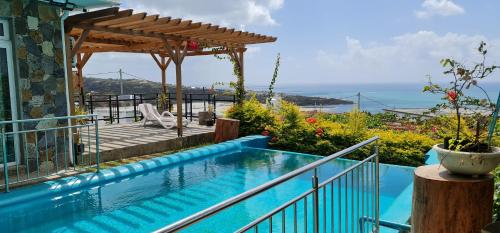 een huis met een zwembad en een pergola bij Villa Paradise Rodrigues in Rodrigues Island
