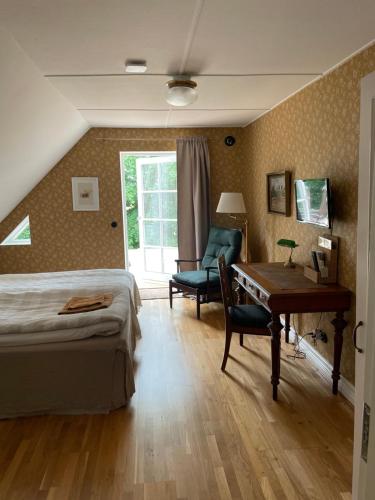 1 dormitorio con cama, escritorio y silla en Bed & Breakfast Vragerups Gård, en Lomma