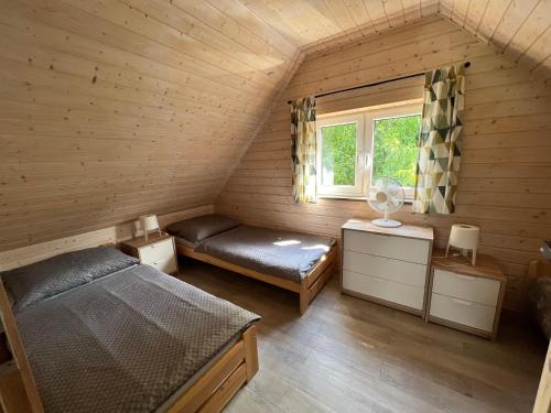 a attic room with two beds and a window at Bliżej Ślęży Domek pod Ślężą in Sulistrowice
