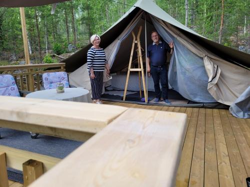 a man and a woman standing in a tent at Hideaway Glamping in Muurame