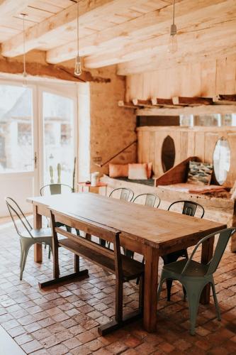 une grande table en bois et des chaises dans une pièce dans l'établissement Maison d'hôtes Bel Estiu, à Saint-Geniès