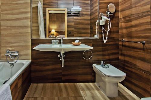 uma casa de banho com um lavatório, um WC e um espelho. em Hotel Doña Blanca em Albarracín