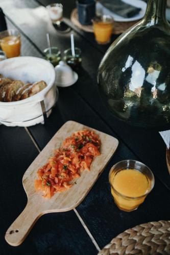 een houten snijplank met voedsel op een tafel bij Maison d'hôtes Bel Estiu in Saint-Geniès
