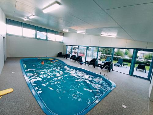 a large swimming pool in a room with chairs at The View - Captains Cove Waterfront Resort in Paynesville