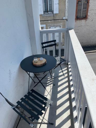 einen blauen Tisch und einen Stuhl auf dem Balkon in der Unterkunft Charmant duplex de 28m2 en plein centre ville in Tarbes