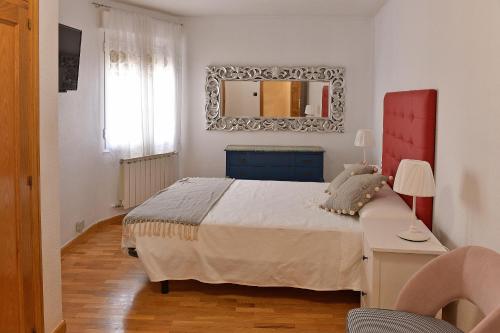 a bedroom with a bed and a mirror on the wall at Villa Teresa in La Bañeza