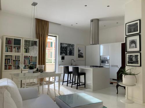 a living room and kitchen with a table and a couch at Rome, Beautiful Apartment in a Vintage Building in Lido di Ostia