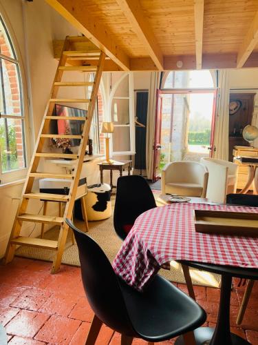 a room with a table and chairs and a ladder at Le petit Chapitre in Pinterville