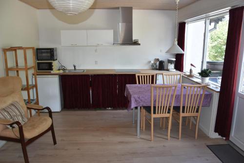 a kitchen with a table and chairs in a room at Henne Strand Ferie Accommodation in Hennebjerg