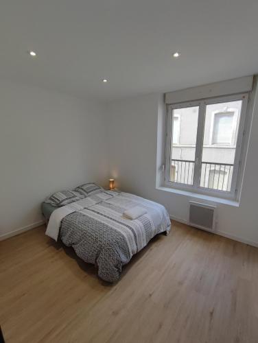 une chambre blanche avec un lit et une fenêtre dans l'établissement Alsace N°3, au Mans