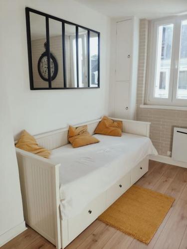 - un lit blanc dans une chambre avec un miroir dans l'établissement Les Coquelicots, à Honfleur