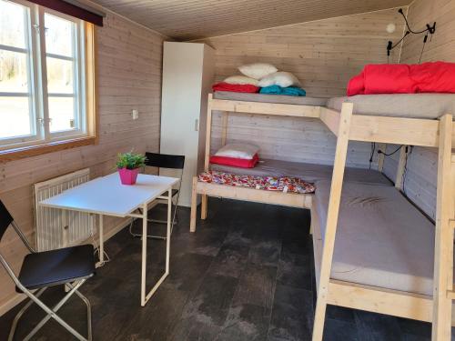a room with two bunk beds and a table at Tydingesjöns Camping & Festplats in Broby