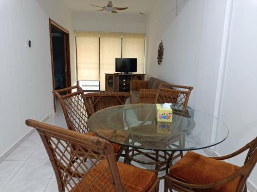 a dining room with a glass table and chairs at PD Paradise Lagoon North B-L5-2 in Port Dickson