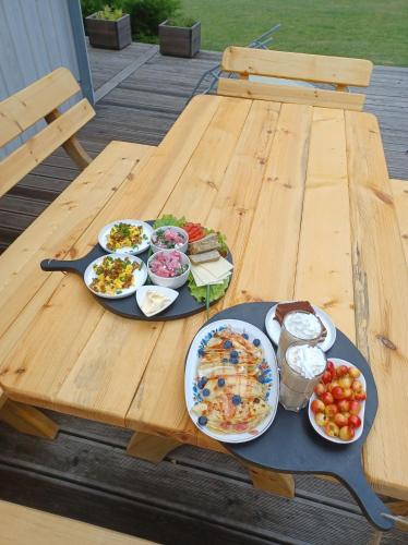 a picnic table with plates of food on it at sosnowelowe in Lamkowo