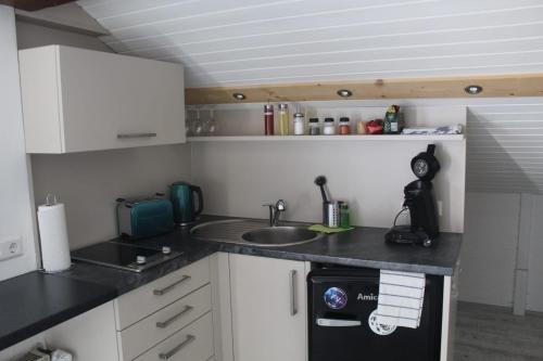 a small kitchen with a sink and a stove at Wohlfühl-Appartement in Maierhöfen