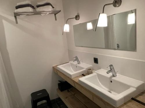 a bathroom with two sinks and a mirror at Authentiek vissershuisje Oud-Knokke in Knokke-Heist