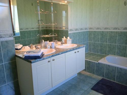 a bathroom with two sinks and a tub at Pontmain (53) Chambre privée proche de Fougères in Pontmain