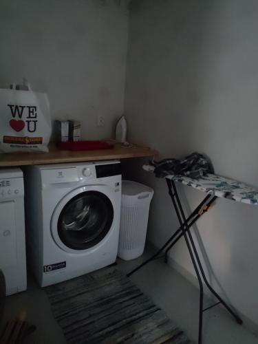 a laundry room with a washing machine and a shelf at Hus Solgläntan in Ruda