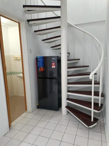 a stairway with a black refrigerator next to a staircase at PD Paradise Lagoon North Penthouse B-2-4 in Kampong Baharu
