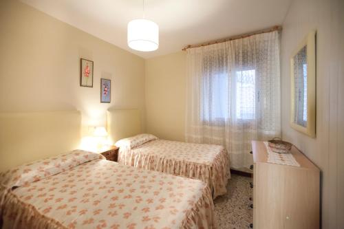 een kamer met 2 bedden en een raam bij Apartamento en Portonovo 200m de la Playa. + WIFI in Portonovo
