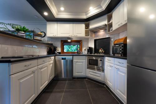 a large white kitchen with white cabinets and appliances at Chalet Heppie People in Doornspijk