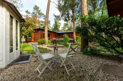 a patio with two chairs and a table at Chalet Heppie People in Doornspijk