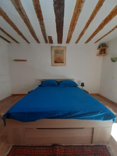 1 dormitorio con 1 cama con edredón azul en La Belle Epoque - au coeur de la Cité médiévale en Briançon
