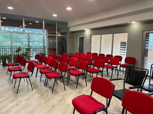 a conference room with red chairs and windows at Kamar Hotel Ijevan in Ijevan