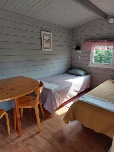 a room with two beds and a table in it at Uttis Home in Nauvo