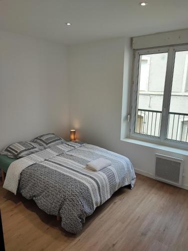 une chambre blanche avec un lit et une fenêtre dans l'établissement Alsace N°2, au Mans