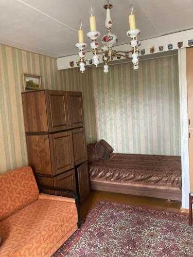 Una sala de estar con un sofá y una lámpara de araña. en Back to USSR, en Sillamäe