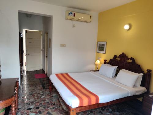 a bedroom with a large bed in a room at WelcomHeritage Panjim Inn in Panaji